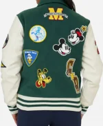 Back view of green Disney varsity jacket featuring Mickey and Friends embroidered patches across the back panel.