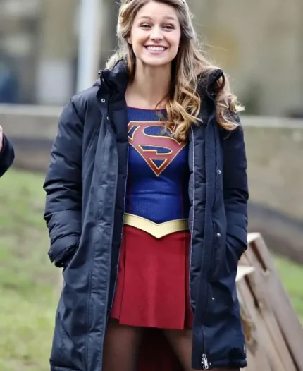 Melissa Benoist as Kara Danvers smiling in blue puffer coat on the Supergirl set