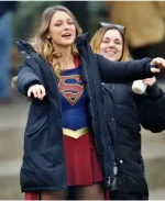 Melissa Benoist in Supergirl blue puffer coat with crew member on set